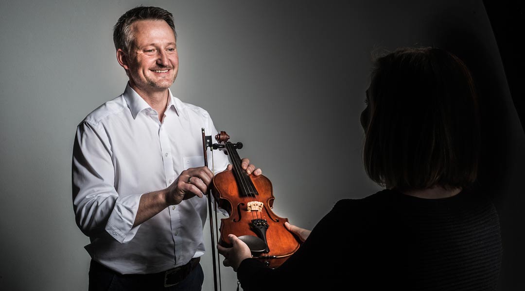 Portraitfoto Mag. Roman Bliem mit Geige